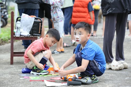 Free Two children playing with paint on the ground Stock Photo