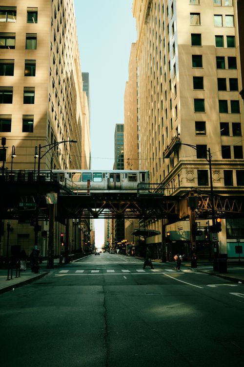 Free A vibrant street view of downtown Chicago with the iconic L train passing above. Stock Photo