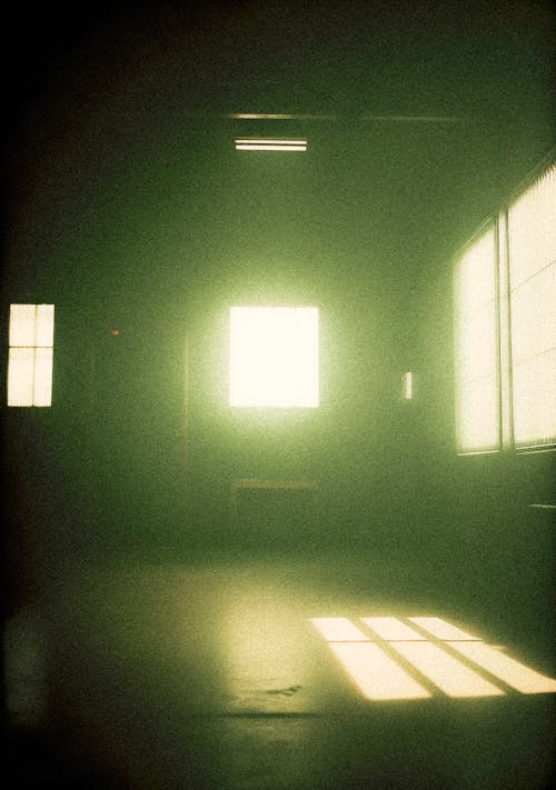 The sun shines through a window in a dark room