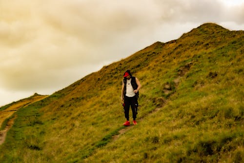 A person walking up a hill on a cloudy day