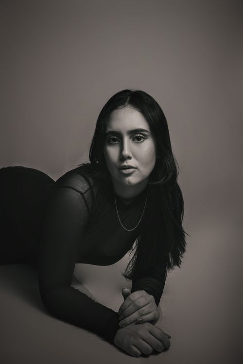 Free Striking black and white portrait of a woman in a studio setting, featuring elegant fashion and pose. Stock Photo