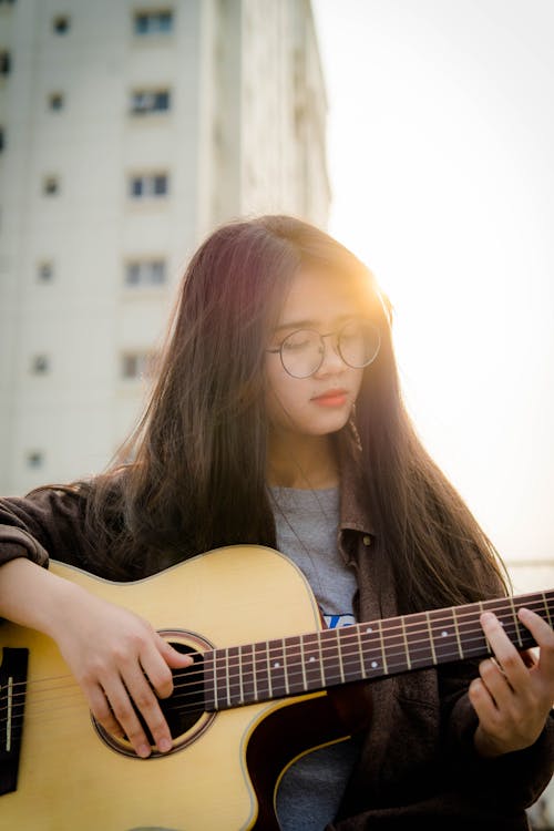 Kostnadsfri bild av artist, asiatisk kvinna, gitarr