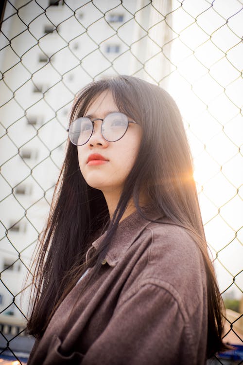 Woman Standing Beside Fence