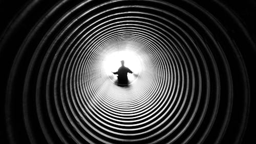 Free 터널 끝에있는 사람의 회색조 사진 Stock Photo