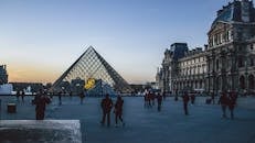 黄昏时分，卢浮宫金字塔被游客包围的景色