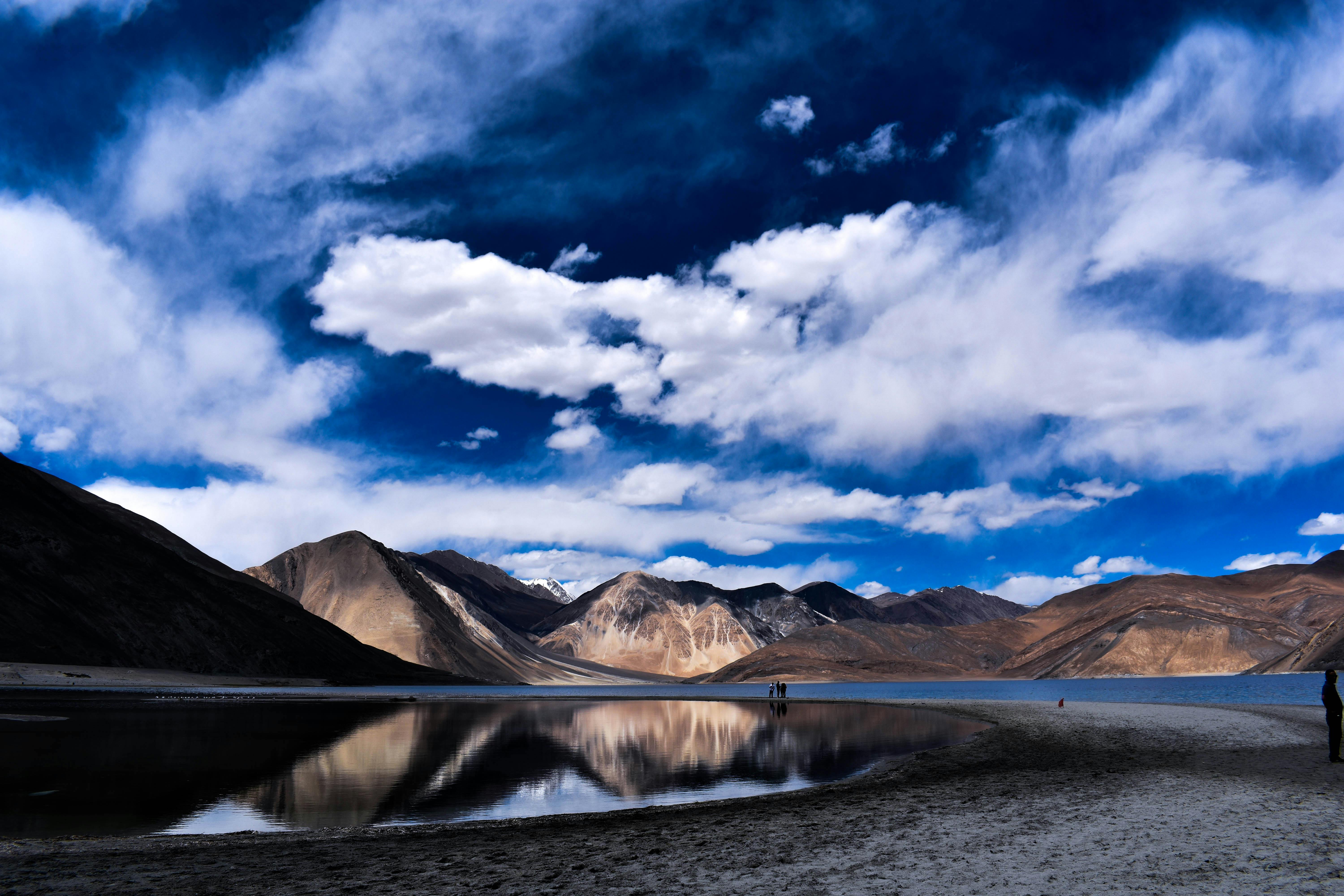 宁静的湖泊映照着令人惊叹的山脉，壮观的景色映衬着云层