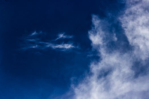 深蓝色的天空中，云彩被描绘得生动而富有戏剧性，唤起了自由与宁静之感
