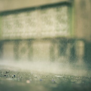 Close-up of raindrops creating a serene atmosphere on a pavement surface.