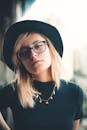 一位戴黑色帽子、眼镜和项链的时尚女性肖像