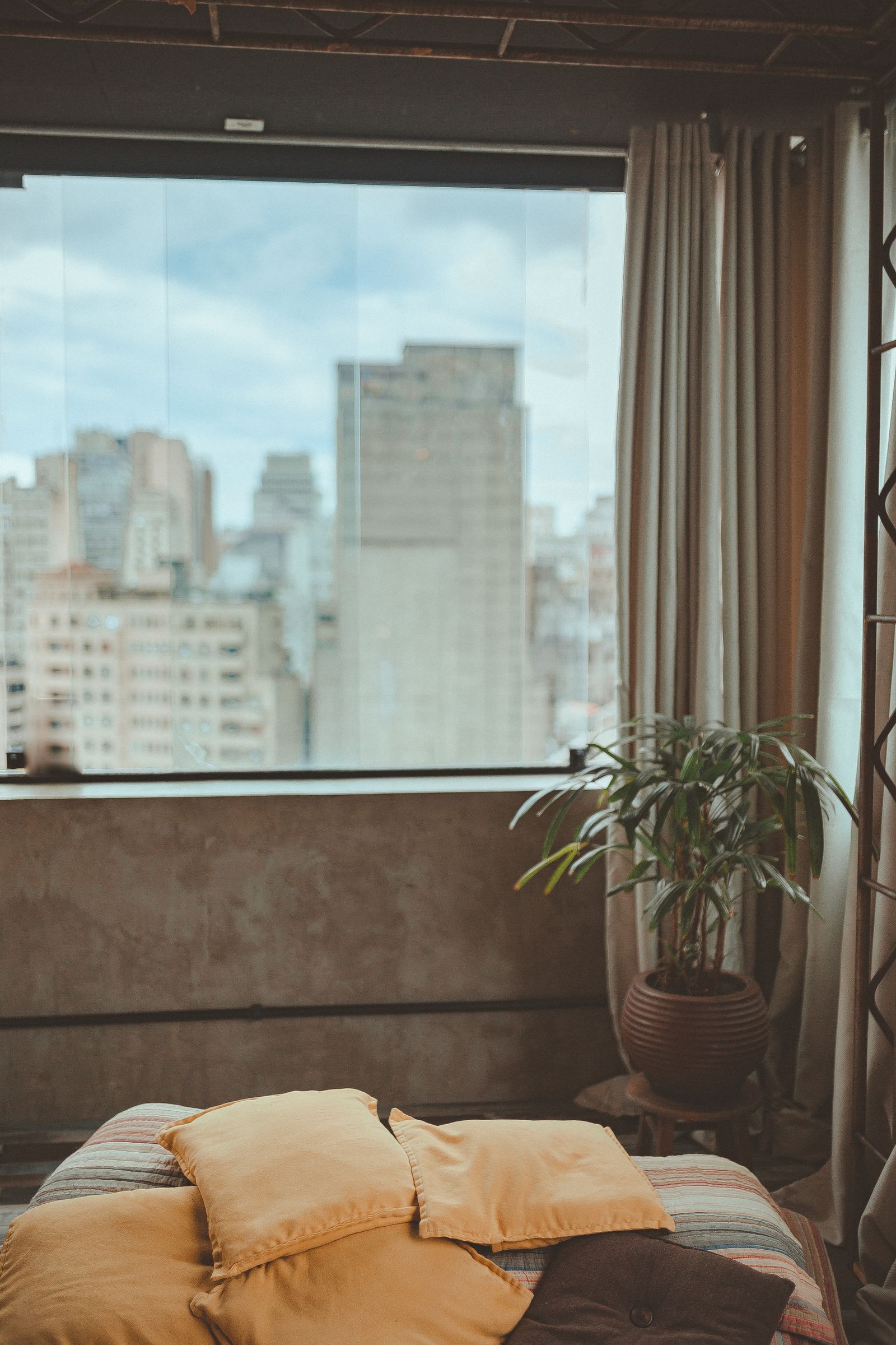 A bedroom with a city skyline through a large window