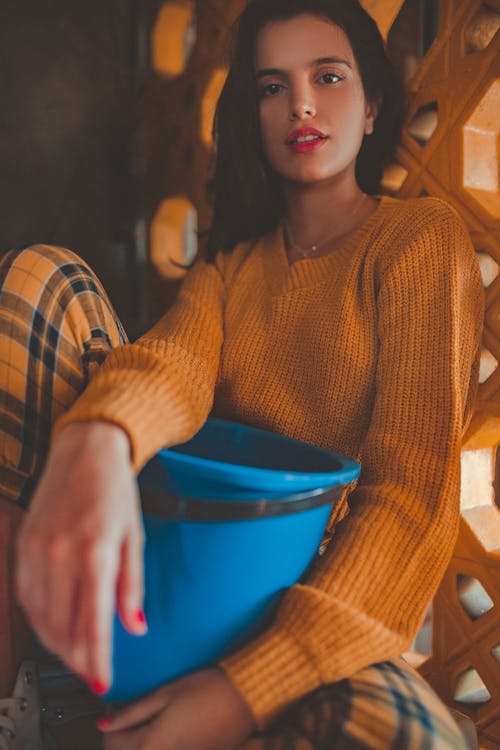 オレンジ色のセーターを着ている女性の写真