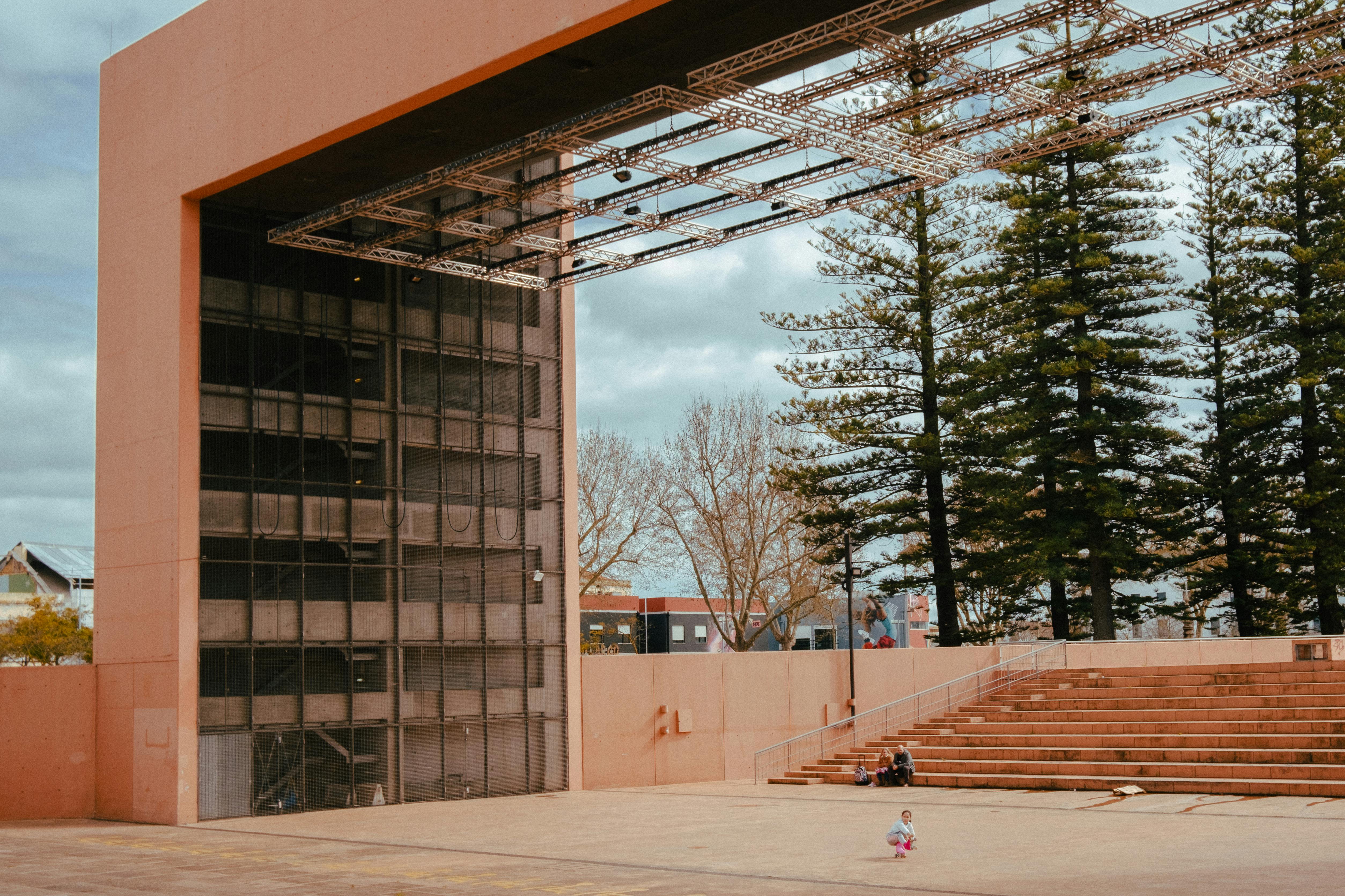 Free Empty outdoor theater in Setúbal, Portugal, featuring a child on the stage under a cloudy sky. Stock Photo