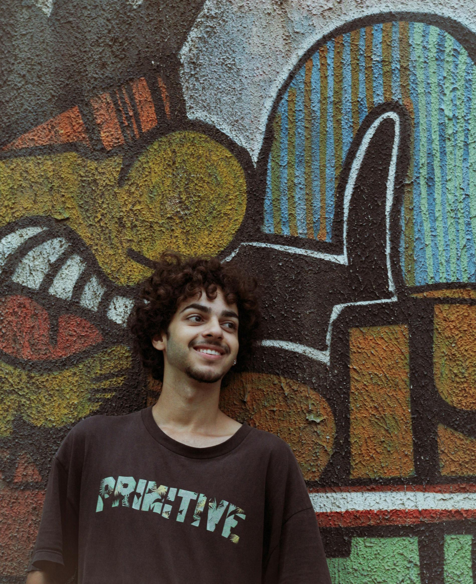 在巴西圣保罗，一名年轻人对着充满活力的街头艺术微笑