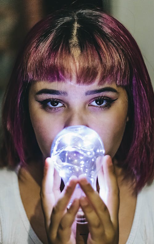 Close-Up Photo of Woman Holding Light Bulb