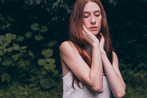 Free Woman Closing Her Eyes Wearing White Tank Top Stock Photo