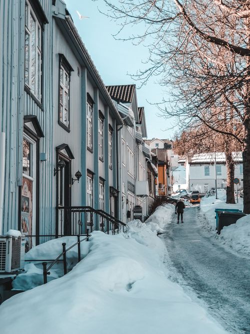 Free A picturesque winter scene of a snow-covered street lined with charming buildings and trees. Stock Photo