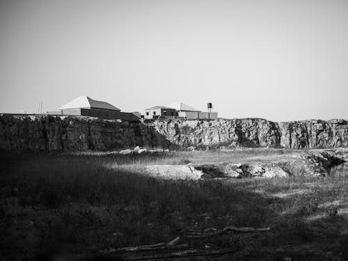 A black and white photo of a building on a cliff