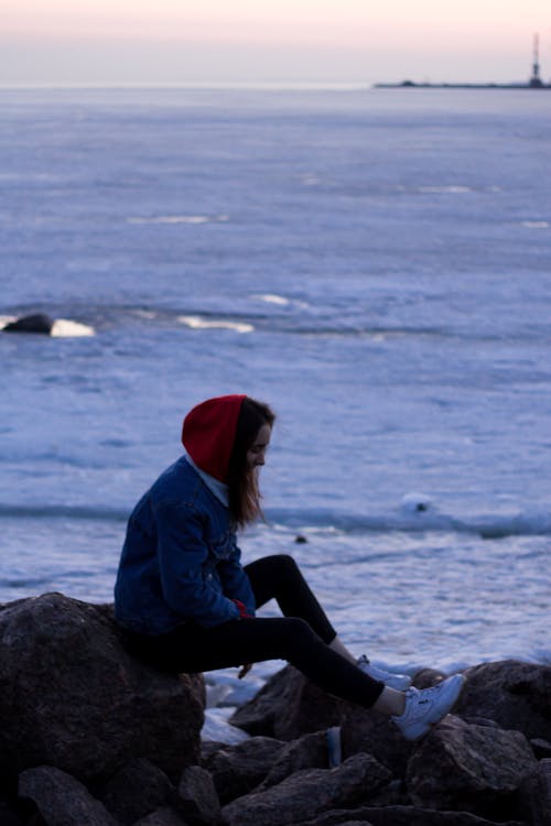 Woman Sitting On Rocks