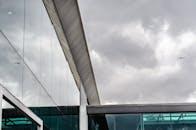 在巴西贝伦，现代建筑的玻璃立面反射着多云的天空，鸟儿在空中飞翔