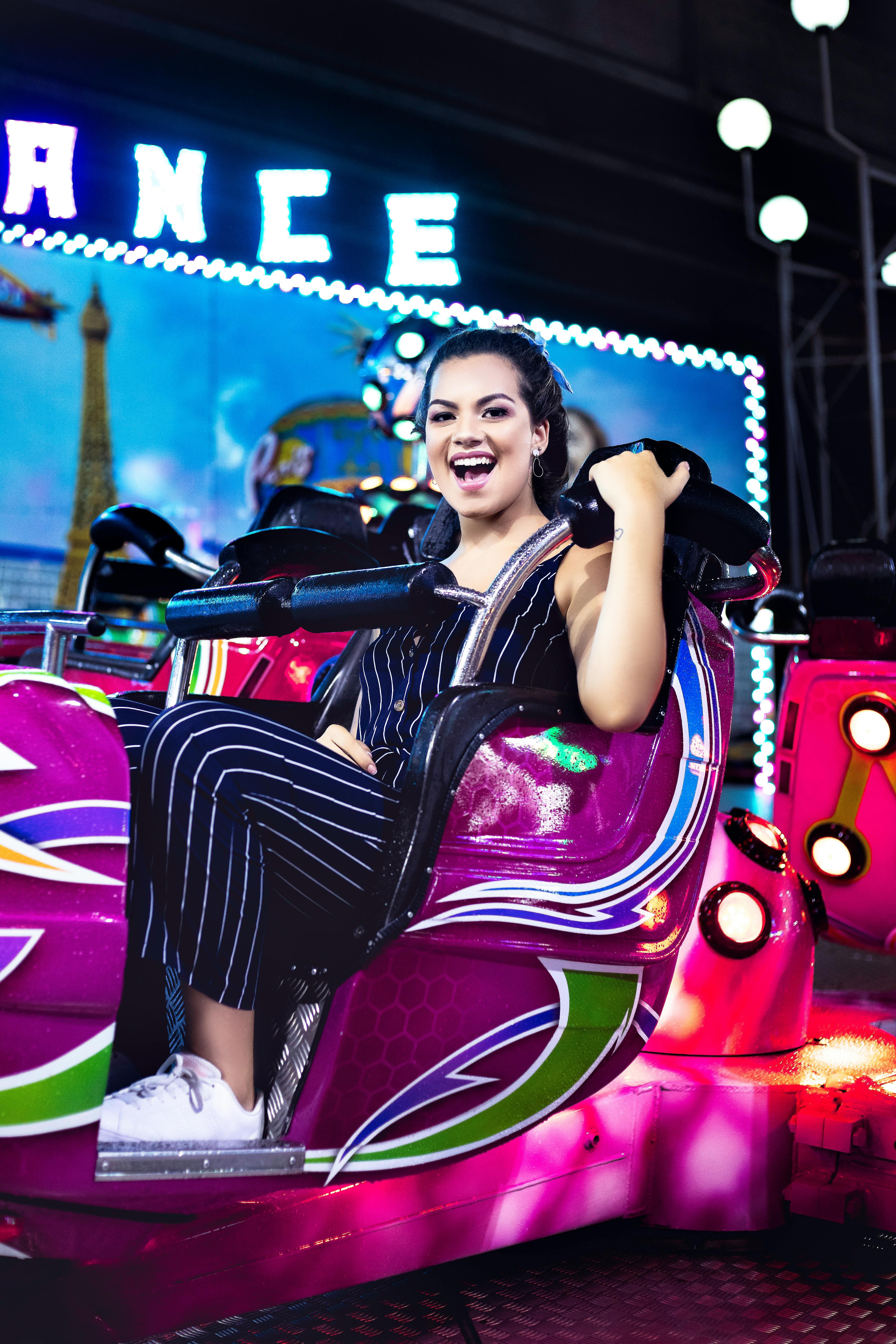 夜晚，快乐的女人在绚丽的灯光下享受充满活力的嘉年华之旅