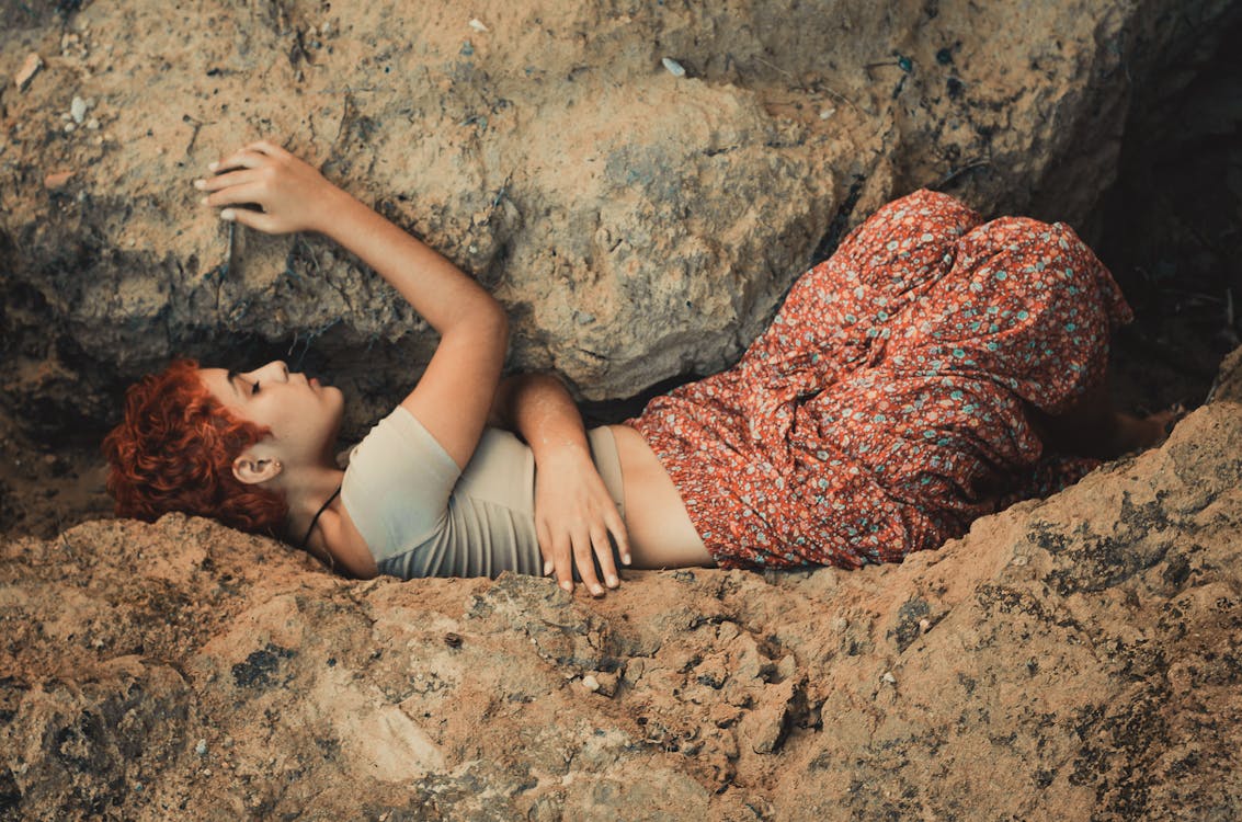 Free Woman Lying in Between Boulders Stock Photo
