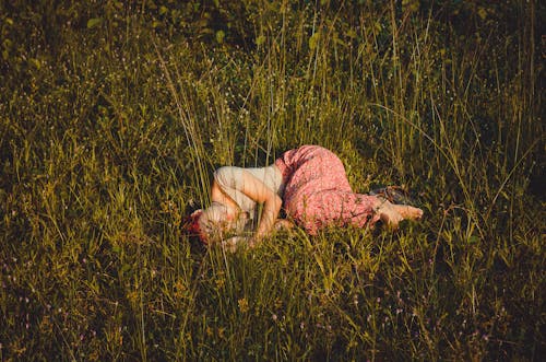 Фотография женщины, лежащей на траве