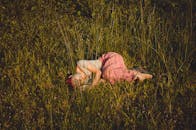 白天，一名女子在草地上休息的画面宁静祥和，捕捉到了自然之美