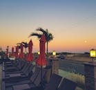 黄昏时分，新泽西州梅角的户外度假胜地宁静宜人，摆放着躺椅和棕榈树