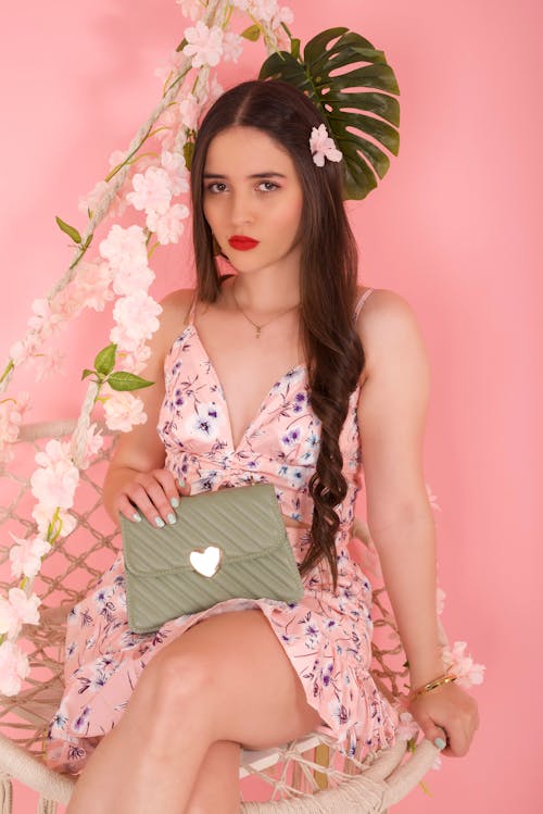 Free Long-Haired Model Sitting on a Chair with a Purse in Hand Stock Photo