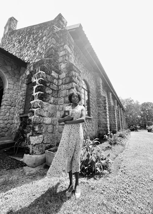 A woman standing in front of a stone building