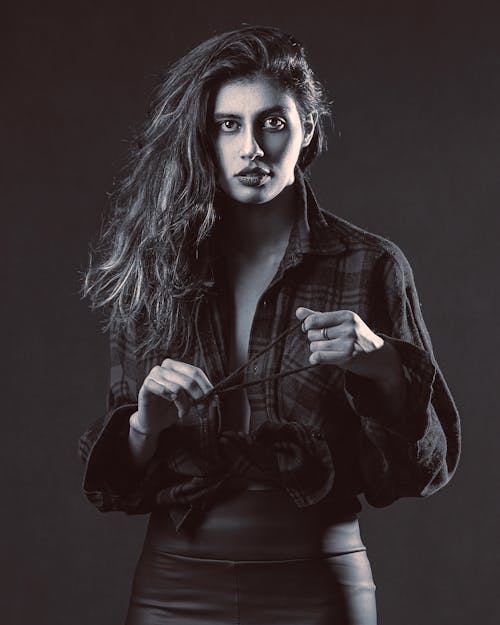 Free A woman in leather pants and a shirt posing for a black and white photo Stock Photo