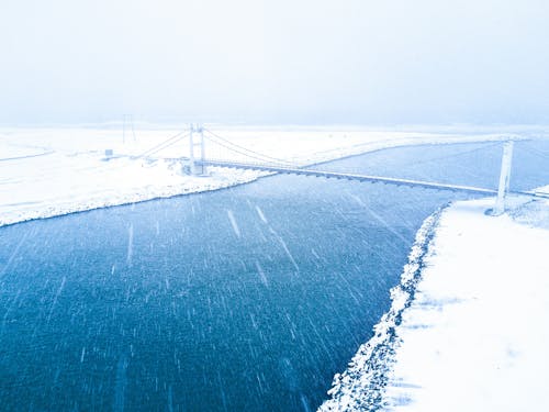 A bridge in the snow with a river in the background