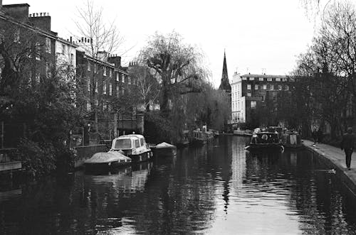 Black and white photo of a canal with buildings