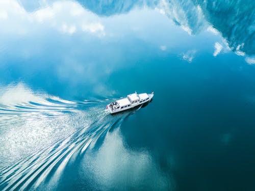 Free A boat traveling through the water in front of mountains Stock Photo