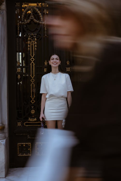 Free A woman in a white dress is standing in front of a door Stock Photo