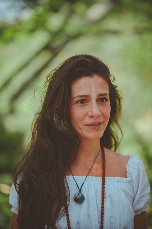 Free Portrait of a woman outdoors with serene expression and natural surroundings. Stock Photo