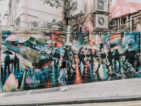 香港街头色彩缤纷的壁画描绘了城市生活，一名女子走过充满活力的街头艺术