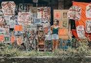 一名年轻女子站在香港一面装饰着充满活力标志和艺术品的艺术墙前