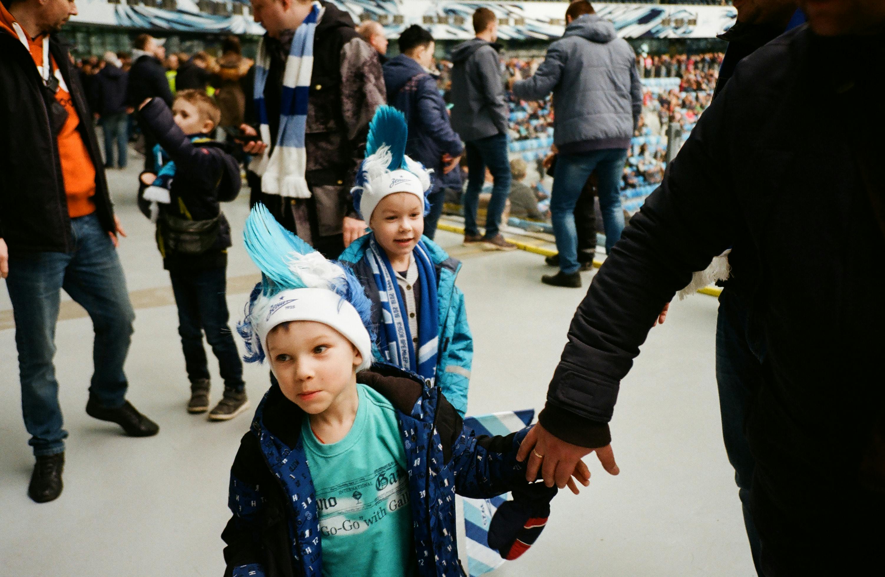 圣彼得堡的孩子们身着蓝色服装，正兴奋地观看一场热闹的足球比赛