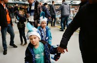 圣彼得堡的孩子们身着蓝色服装，正兴奋地观看一场热闹的足球比赛