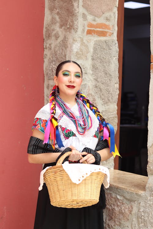 Free A woman in traditional mexican clothing holding a basket Stock Photo