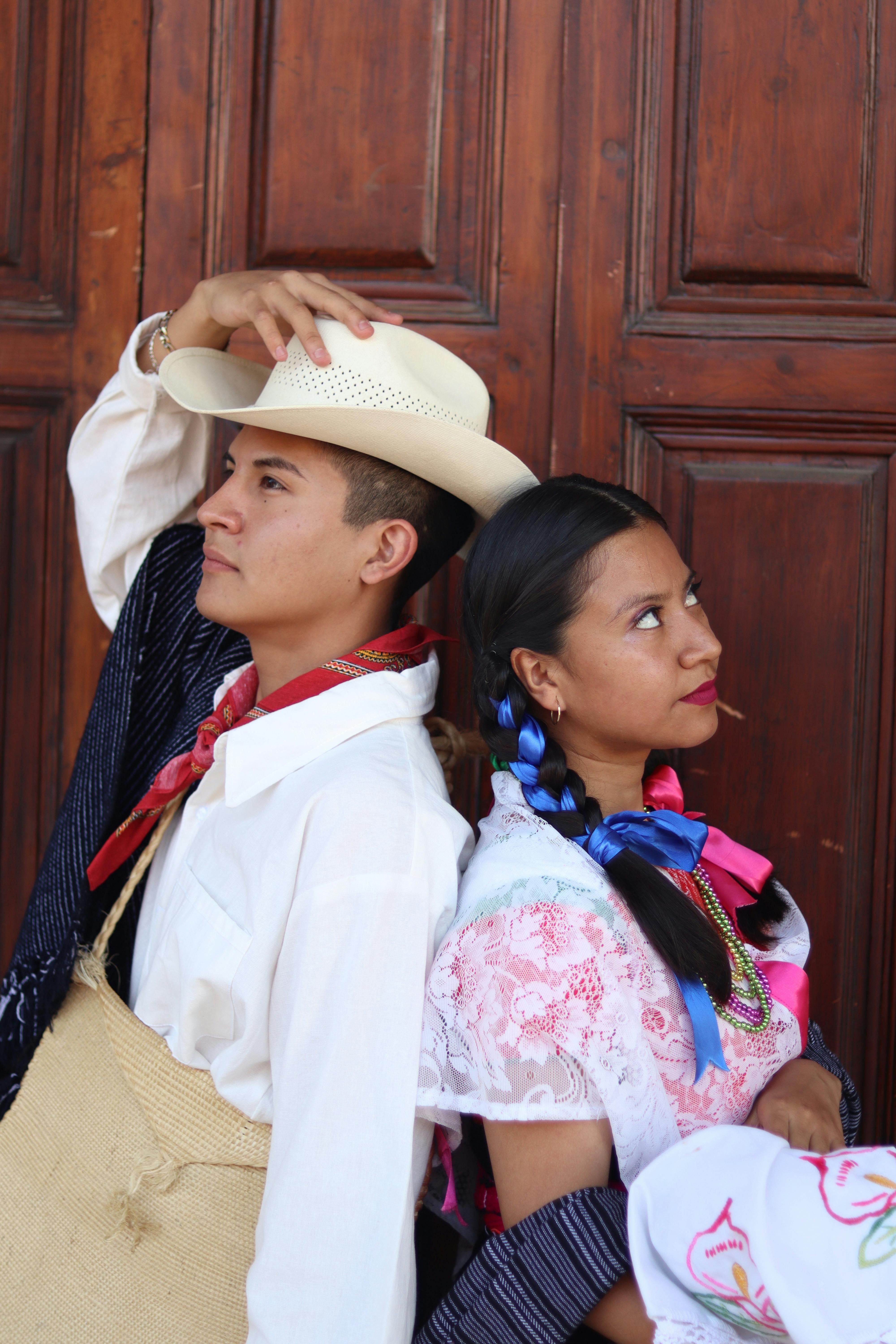 man and woman in traditional clothing posing back to back