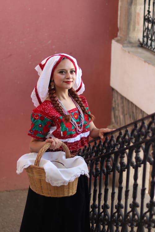 Free A woman in traditional clothing holding a basket Stock Photo