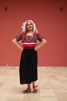 Smiling woman in vibrant traditional Mexican attire with folk clothes and bead necklace. — photo by Astrid Sosa