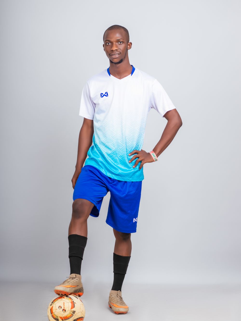 Football player posing with a ball on a white studio background