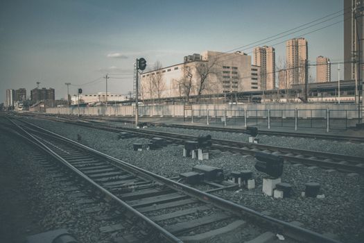 铁路轨道穿过城市工业景观，展现了交通基础设施