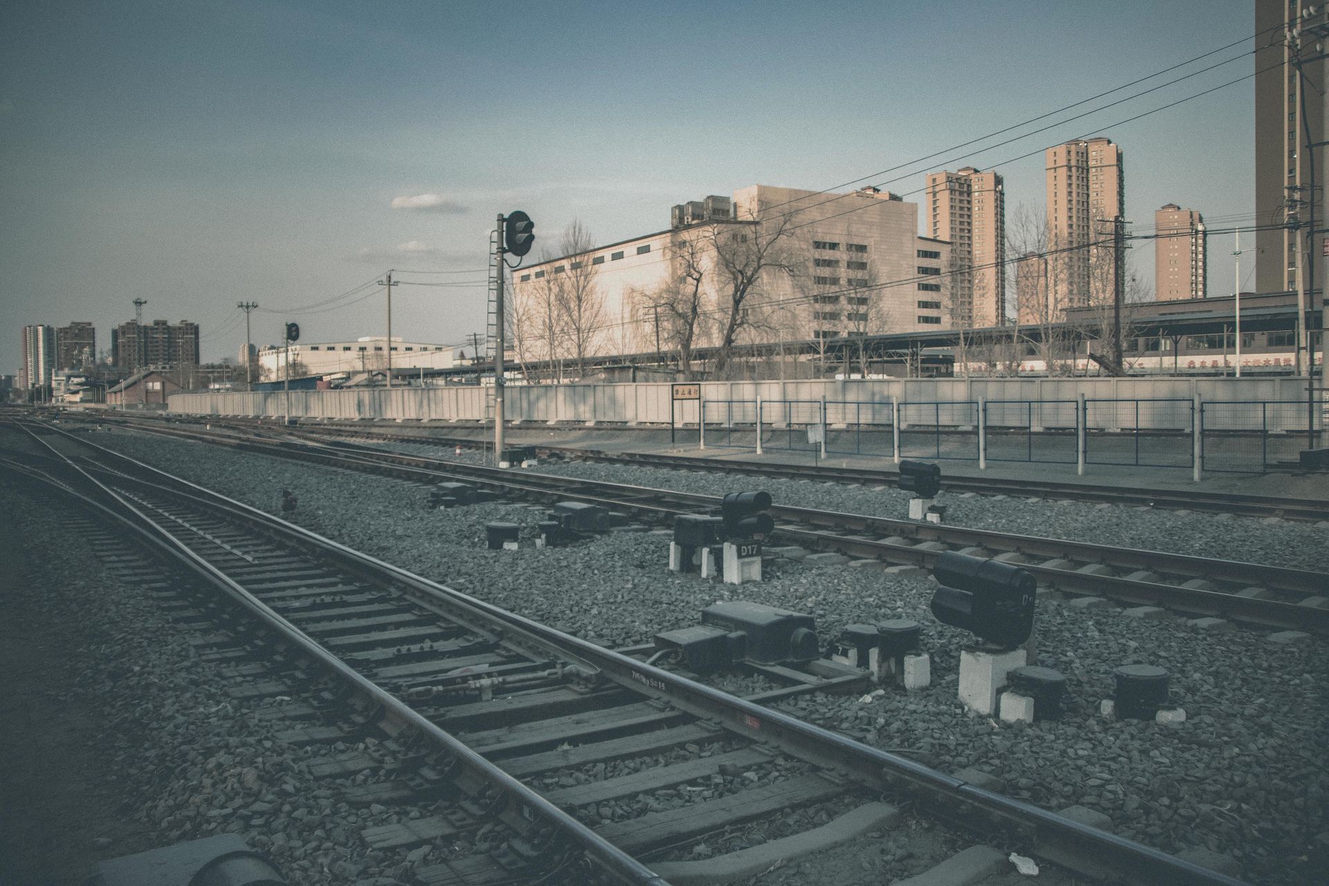 Railway tracks extending through an urban industrial cityscape, showcasing transportation infrastructure.