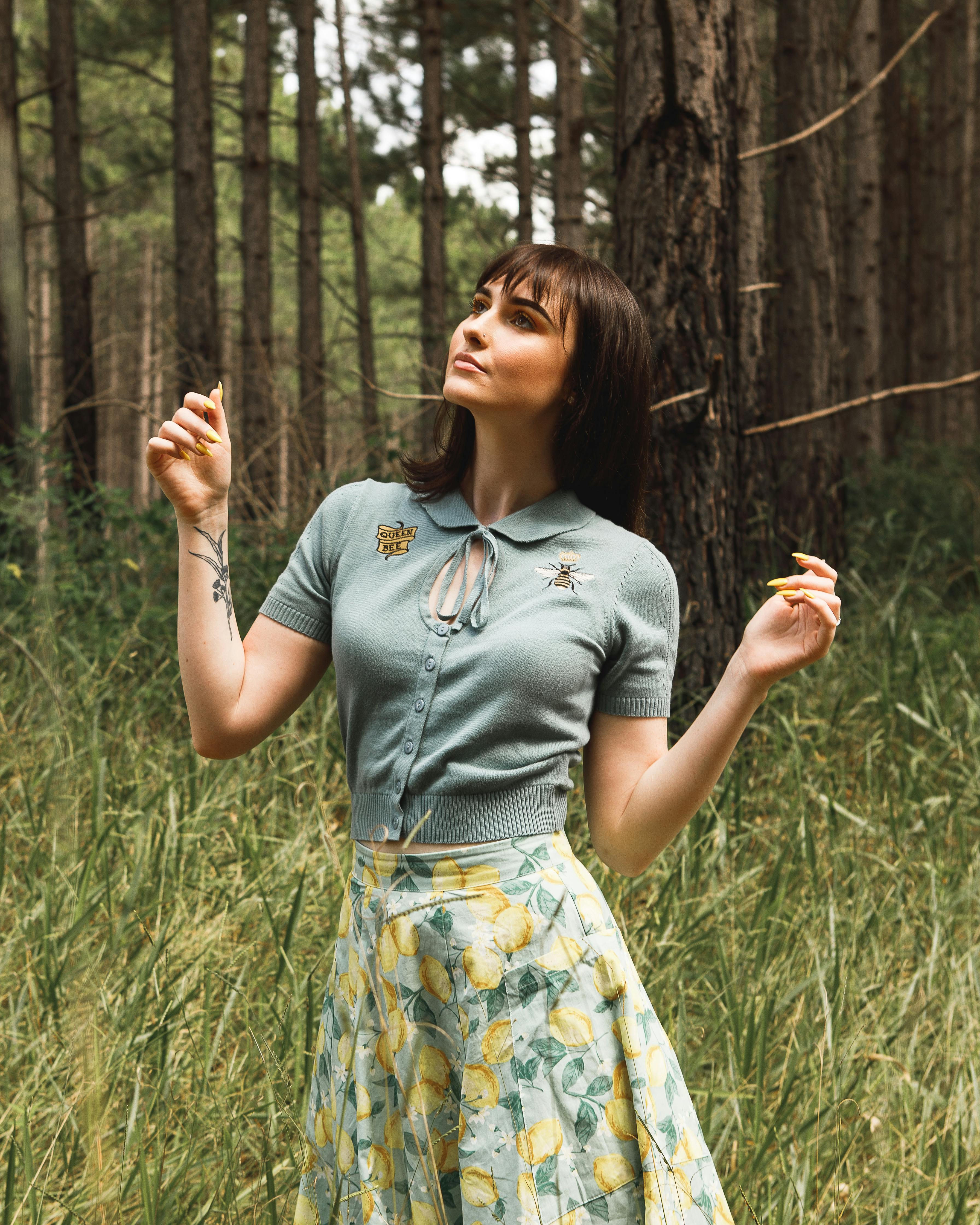 白天，时尚的女人在郁郁葱葱的森林草地上享受大自然