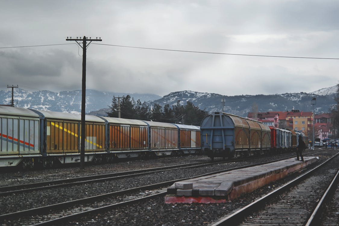 Kereta Berlari Di Jalur Kereta API Di Bawah Langit Kelabu Pada Siang Hari