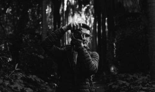Free Black and white portrait of a man photographing in a forest. Stock Photo